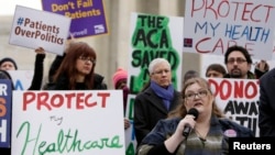 FILE - Laura Hayes, with microphone, of Fort Wayne, Indiana, tells fellow protesters how the Affordable Care Act helped her with health costs, during a protest in front of the Supreme Court in Washington, March 4, 2015.