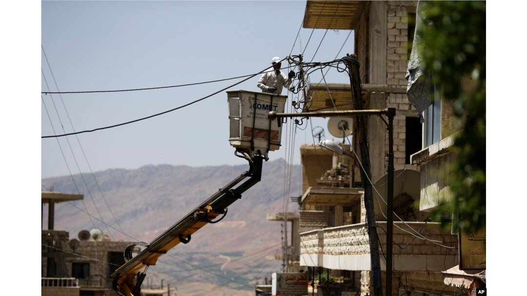 A Syrian electricity worker fixes power cables, at the town of Madaya in the Damascus countryside, Syria, May 18, 2017.