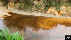 FILE - Oil from a spill pollutes the Okuku River in Ogoniland, Nigeria, on Sept. 16, 2023. Amnesty International on July 5, 2024, raised a red flag about two companies the Nigerian government has hired to assess a proposed sale of Shell's onshore assets.