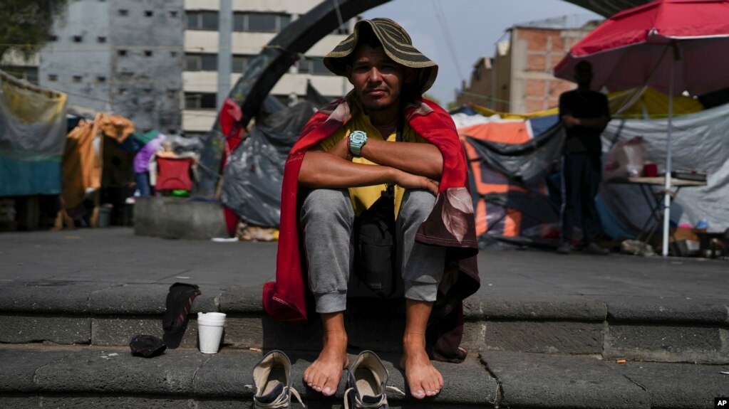 El inmigrante venezolano Cristo Pérez, de 33 años, sentado al sol en un campamento de migrantes frente a la Iglesia de La Soledad en la Ciudad de México, el 31 de julio de 2024.