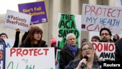 FILE - Laura Hayes, with microphone, of Fort Wayne, Indiana, tells fellow protesters how the Affordable Care Act helped her with health costs, during a protest in front of the Supreme Court in Washington, March 4, 2015.