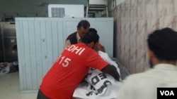 Emergency workers from local NGO Eidhi Foundation covering dead bodies in a morgue after an attack on the minority Hazara Shi'ites in Pakistan's city Quetta, Oct. 9, 2017. (Abdul Sattar Kakar/VOA Urdu)