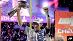 New England Patriots quarterback Tom Brady holds up Vince Lombardi Trophy after the Patriots defeated the Seattle Seahawks 28-24 in NFL Super Bowl XLIX football game in Glendale, AZ.