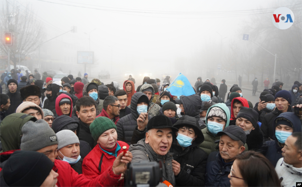 Manifestantes sostienen lo que sería munición de la policía de Kazajistán. En medio de los disturbios han sido quemados algunos vehículos y oficinas como la del alcalde.
