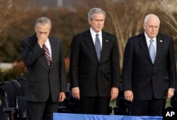 FILE - Secretary of Defense Donald Rumsfeld, left, pauses as President George W. Bush, and Vice President Dick Cheney participate in Rumsfeld's farewell ceremony at the Pentagon in Washington, Dec. 15, 2006.