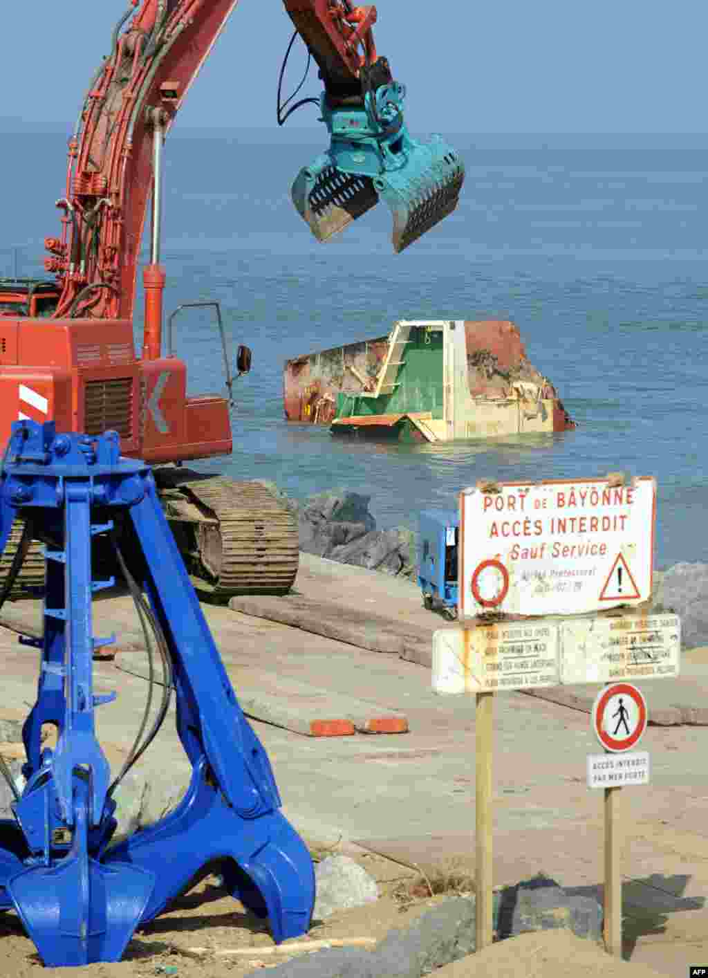 Picture shows cranes and part of the wreckage of the Spanish cargo ship &#39;Luno&#39; in Anglet, southwestern France, during the dismantling of the ship which has broken into three sections after a shipwreck in February 2014. The 20-year-old Spanish vessel split in two when winds and waves smashed it up against an artificial breakwater on February 5. The crew of 11 were rescued by helicopter in perilous conditions.