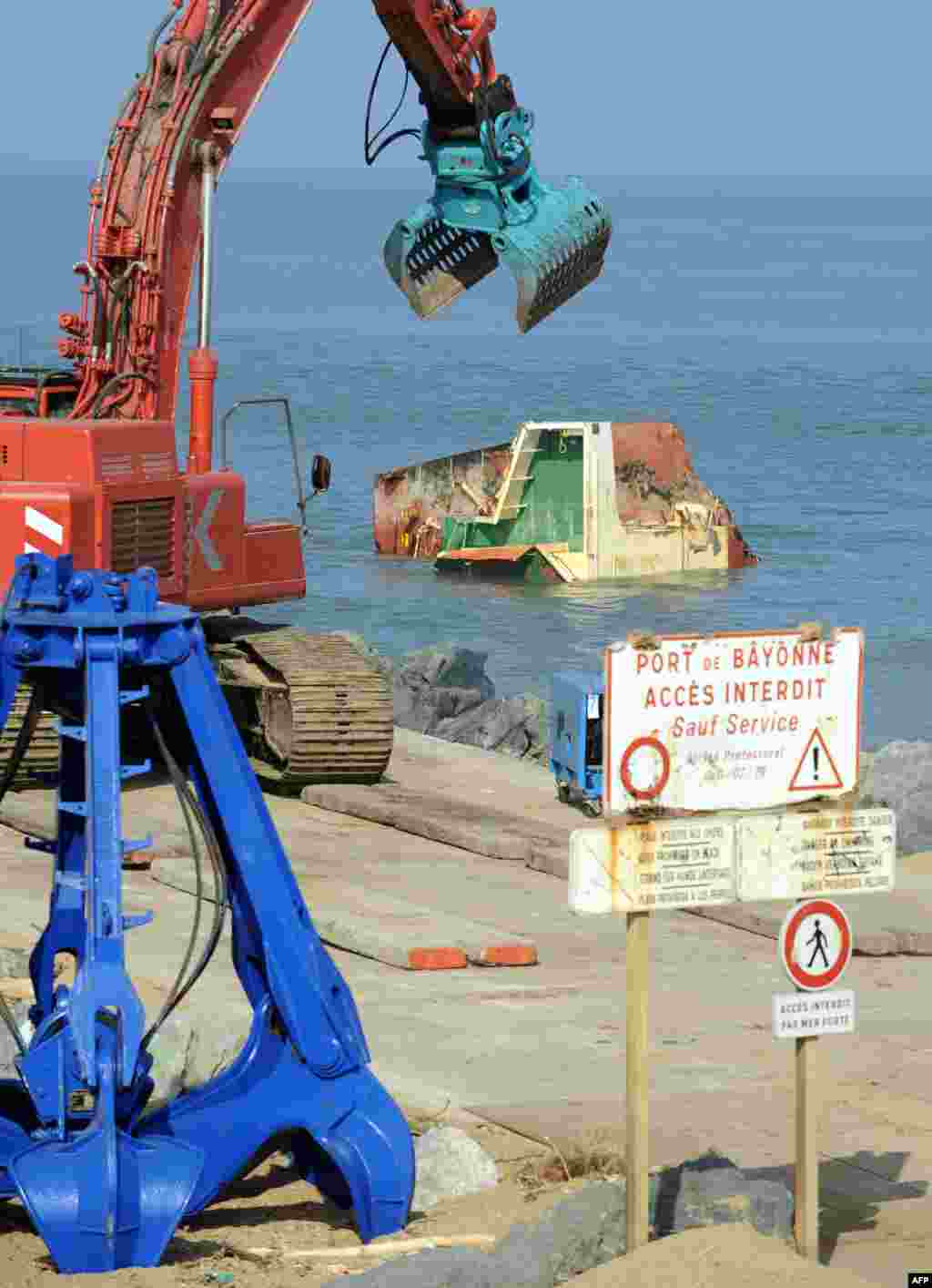 Picture shows cranes and part of the wreckage of the Spanish trade ship 'Luno' in southwestern France. The ship broke into three pieces after a shipwreck in February.