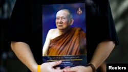 FILE - A man holds a portrait of Thailand's Supreme Patriarch, Somdet Phra Nyanasamvara Suvaddhana Mahathera, at Chulalongkorn Hospital in Bangkok, October 25, 2013. 
