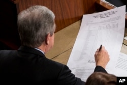 Sen. Roy Blunt, R-Mo., left, signs off on an official tally following a joint session of Congress to count Electoral College votes in Washington, Jan. 6, 2017.