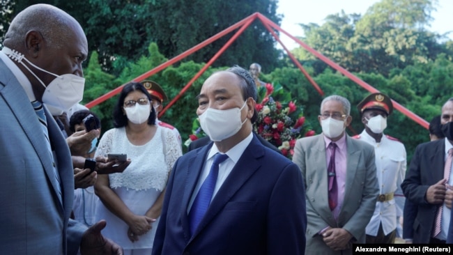 Presiden Vietnam Nguyen Xuan Phuc berbicara kepada Wakil Presiden Pertama Kuba Salvador Antonio Valdes Mesa setelah menghadiri upacara peletakan karangan bunga di monumen Ho Chi Minh di Havana, Kuba, 19 September 2021. (Foto: REUTERS/Alexandre Meneghini)