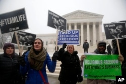 Demonstrators participate in a rally in front of the Supreme Court in Washington, Tuesday, March 25, 2014, as the court heard oral arguments in the challenges of President Barack Obama's health care law requirement that businesses provide their female employees with health insurance that includes access to contraceptives.