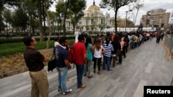 Hundreds of people line up to enter the Palace of Fine Arts for a public viewing of the ashes of late Colombian Nobel laureate Gabriel Garcia Marquez in Mexico City, April 21, 2014. 