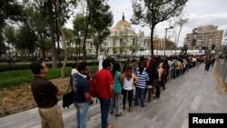 Hundreds of people line up to enter the Palace of Fine Arts for a public viewing of the ashes of late Colombian Nobel laureate Gabriel Garcia Marquez in Mexico City, April 21, 2014. 
