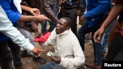 A man holds his South African identity document after being attacked by a mob in Pretoria, South Africa, Feb. 24, 2017. 