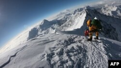 FILE - Mountaineers make their way to the summit of Mount Everest, as they ascend on the south face from Nepal, May 17, 2018.