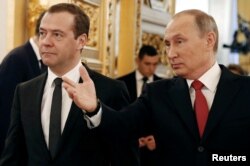 FILE - Russian President Vladimir Putin and Prime Minister Dmitry Medvedev walk after the president delivered his annual state of the nation address at the Kremlin in Moscow, Dec. 1, 2016.