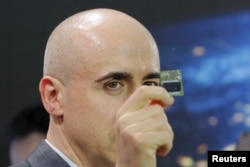 Investor Yuri Milner holds a Starchip, a microelectronic component spacecraft, during an announcement of the Breakthrough Starshot initiative with physicist Stephen Hawking and Avi Loeb in New York, April 12, 2016.