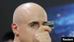 Investor Yuri Milner holds a Starchip, a microelectronic component spacecraft, during an announcement of the Breakthrough Starshot initiative with physicist Stephen Hawking in New York, April 12, 2016.