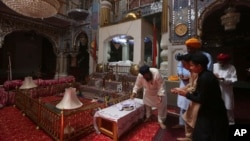 FILE - People from Pakistan Sikh community visit their temple in Peshawar, Pakistan, Aug. 8, 2017. Today Sikhs are battling with the Pakistan government for ownership of dozens of Sikh temples, and while it is slow going they have managed to reclaim some of their temples.