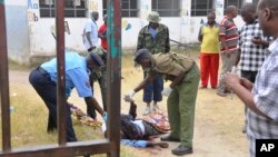 Security officers examine the body of a pastor George Karidhimba Muriki of the Maximum Revival Center after he was shot dead by armed gunmen in Mombasa, Kenya, Jan. 11, 2015.