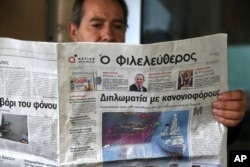 FILE - A man reads a Cypriot newspaper with a front page carrying a photo montage about Turkey's actions over Cyprus and international companies exploration for gas in the eastern Mediterranean in capital Nicosia, Cyprus, Feb. 13, 2018.