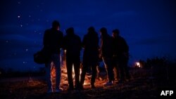 Migranti okupljeni oko vatre u blizini tursko-grčke granice. (Foto: AFP/Ozan Kose)