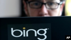 FILE - Microsoft vendor Patrick Porter works on a laptop marked with the logo for Bing in a cafeteria at the company in Redmond, Washington.