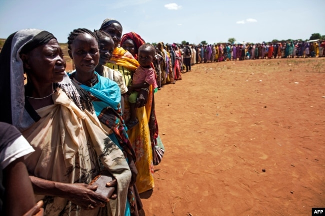 FILE - Internally displaced people, who recently arrived in Wau, South Sudan due to armed clashes in surrounding villages, wait to be registered by the International Organization for Migration and the World Food Program, May 11, 2016.