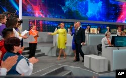 Russian President Vladimir Putin, center, arrives to host his annual "Direct Line" call-in show in Moscow, June 7, 2018.