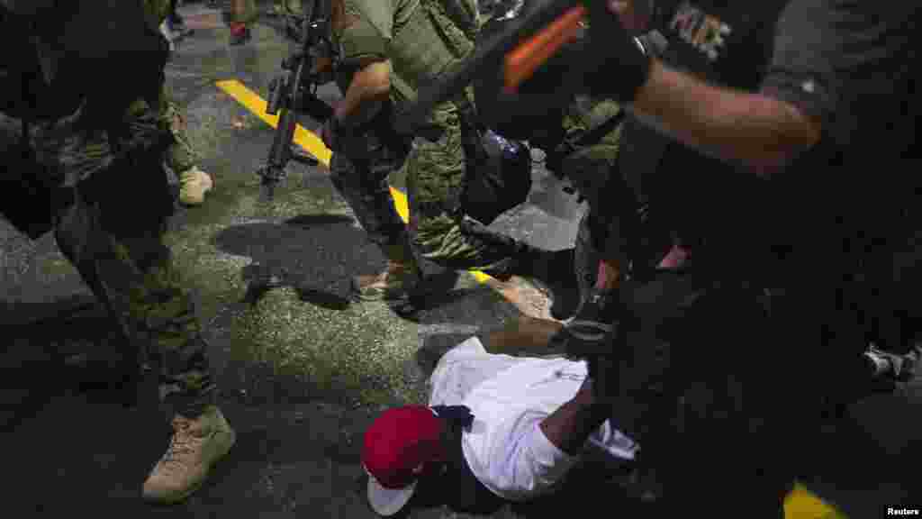 Security forces detain a demonstrator during a protest against the shooting of unarmed black teen Michael Brown in Ferguson, Missouri, Aug. 20, 2014.