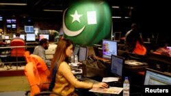 An employee works at the control room of the Geo News television channel in Karachi, Pakistan, April 11, 2018. 