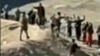 An image grab taken from a video posted online by the Syrian Democratic Forces (SDF) on Jan. 24, 2022, reportedly shows Islamic State (IS) group detainees surrendering to SDF fighters outside the Ghweiran prison in the northern Syrian city of Al-Hasakah. 