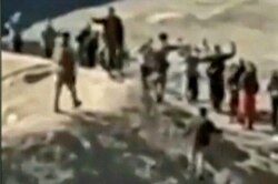 An image grab taken from a video posted online by the Syrian Democratic Forces (SDF) on Jan. 24, 2022, reportedly shows Islamic State (IS) group detainees surrendering to SDF fighters outside the Ghweiran prison in the northern Syrian city of Al-Hasakah.