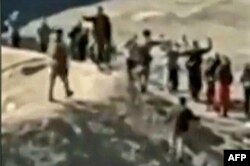 An image grab taken from a video posted online by the Syrian Democratic Forces (SDF) on Jan. 24, 2022, reportedly shows Islamic State (IS) group detainees surrendering to SDF fighters outside the Ghweiran prison in the northern Syrian city of Al-Hasakah.