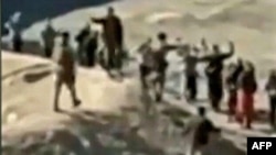 An image grab taken from a video posted online by the Syrian Democratic Forces (SDF) on Jan. 24, 2022, reportedly shows Islamic State (IS) group detainees surrendering to SDF fighters outside the Ghweiran prison in the northern Syrian city of Al-Hasakah. 