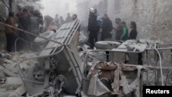 Men inspect a site hit by what activists said was a barrel bomb dropped by forces loyal to Syria's President Bashar al-Assad on al-Marjeh neighborhood of Aleppo, Nov. 12, 2014. 