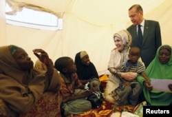 FILE - Turkey's Prime Minister Recep Tayyip Erdogan (top) and his wife Emine Erdogan visit a camp for displaced people in Mogadishu, Aug. 19, 2011.