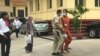 Ratt Roth Mony, wearing an orange jumpsuit and face mask, is being escorted by a national police officer after a hearing at the Supreme Court in Phnom Penh, Cambodia, July 1, 2020. (Hul Reaksmey/VOA Khmer) 