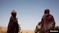 Des femmes attendent de charger leurs chariots avec des sacs de riz et des bouteilles d'huile de cuisson dans un centre de distribution alimentaire géré par "Action contre la faim" à Tarenguel, région du Gorgol, en Mauritanie le 30 mai 2012. REUTERS / Susana Vera