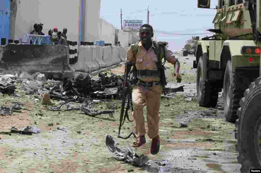 2013年6月19日，摩加迪沙一处联合国大院遭到武装分子袭击后，安全部队与激进分子交火，一名索马里政府军士兵紧急跑向隐蔽地点。