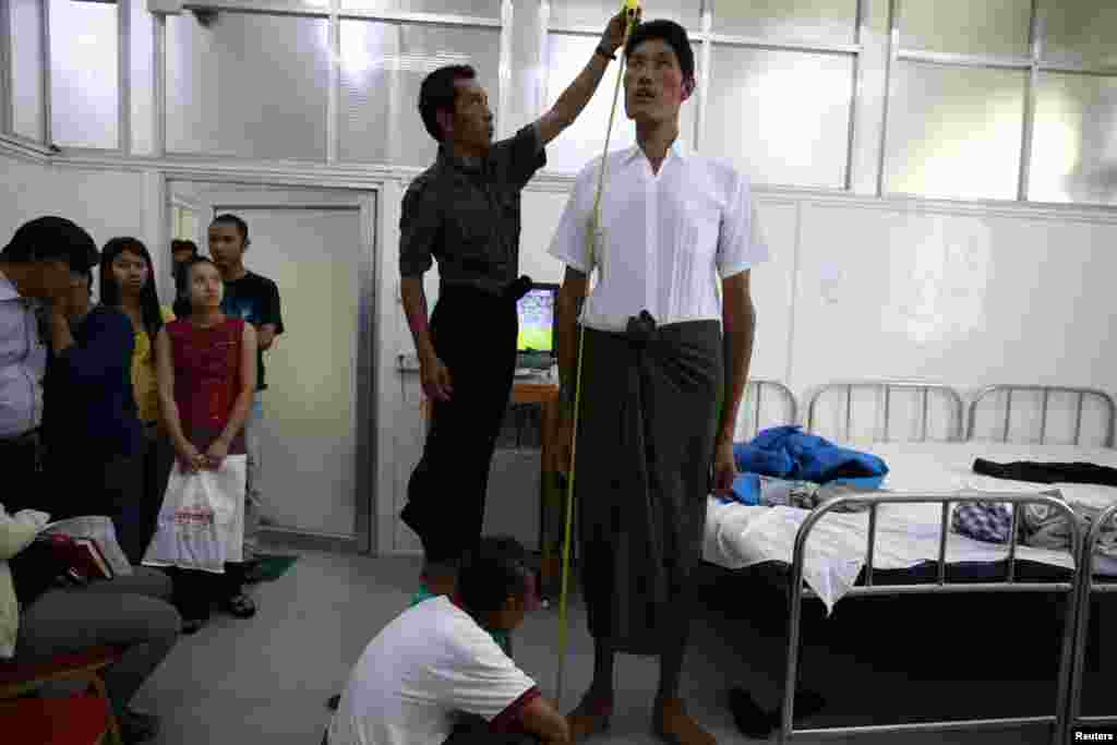 Win Zaw Oo, 36, has his height measured during a medical check-up at a clinic in Rangoon. Win Zaw Oo, who stands at 7 feet 5 inches tall, is Burma's tallest man, according to the medical team.