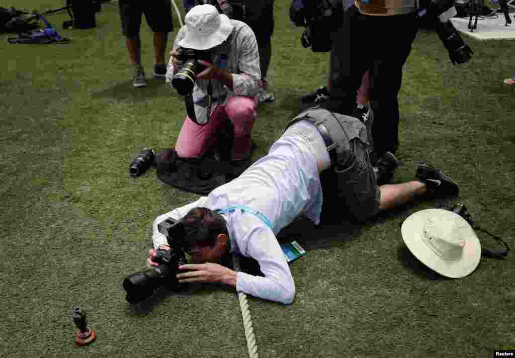 Photographers take pictures of a replica Ashes urn on the Gabba cricket ground in Brisbane, Australia. The Ashes is the notional prize in Test cricket series played between England and Australia. England and Australia will play for the Ashes in a five-test match series starting in Brisbane on Nov. 21. 