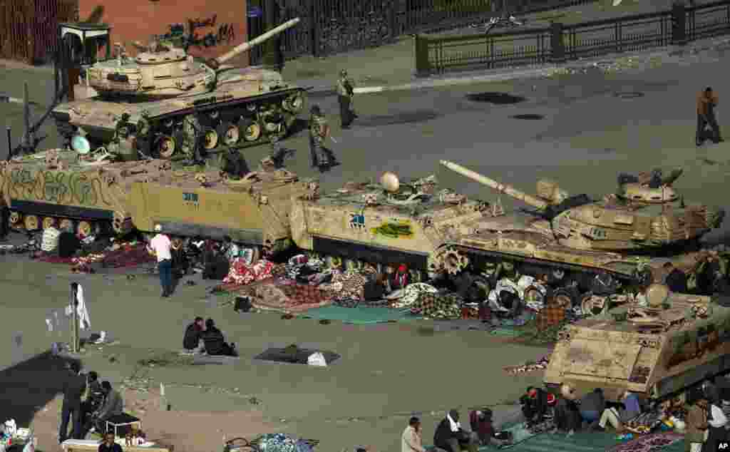 Egyptian anti-Mubarak protesters camp out next to Army tanks and armored vehicles near Tahrir square in Cairo, Egypt, Wednesday, Feb. 9, 2011.
