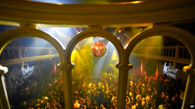 People dance in close proximity at Paradiso pop venue, club and cultural center, in Amsterdam, Sept. 25, 2021, the day the Netherlands dropped the coronavirus-related 1.5-meter distancing rule.