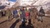 In this photo provided by the Nepalese army, soldiers carry an avalanche victim to an airlift transfer point in Thorong La pass area, Nepal, Oct. 15, 2014.