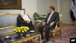 In this photo released by the Egyptian Presidency, Saudi Arabia's ambassador to Egypt Ahmed Kattan meets with Egyptian President Mohammed Morsi, in Cairo, July 7, 2012.