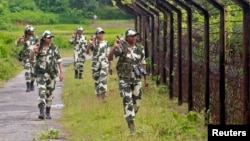 FILE - Female personnel of India's Border Security Force patrol along the fencing of the India-Bangladesh international border ahead of India's Independence Day celebrations, at Dhanpur village in India's northeastern state of Tripura, August 2014.