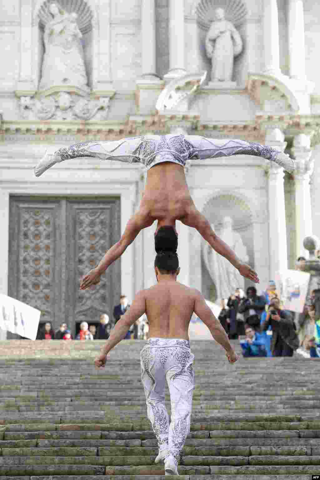 Dua bersaudara Vietnam Quoc Co Giang (bawah) dan Quoc Nghiep Giang mencoba memecahkan rekor Guinness dengan menaiki tangga dalam posisi begini di Girona, Spanyol.