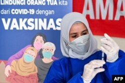 Seorang nakes mempersiapkan suntikan vaksin COVID-19 Moderna untuk program vaksinasi booster di Barona Jaya, pinggiran Banda Aceh, 13 Agustus 2021. (CHAIDEER MAHYUDDIN / AFP )