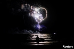 A man watches fireworks on the beach during U.S. Independence Day celebrations in Atlantic Beach, New York July 3, 2016, ahead of the July 4th holiday.